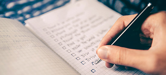 hand holding pen with checklist hand holding pen with checklist